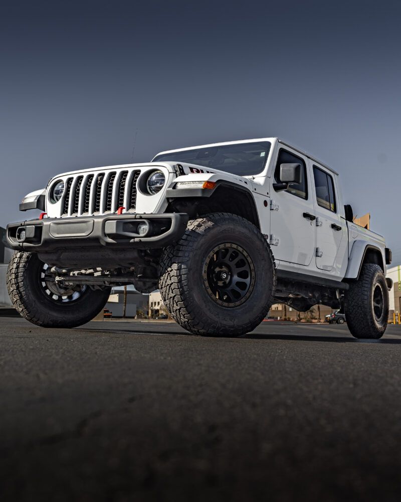 White Jeep Gladiator on black wheels and all-terrain tires