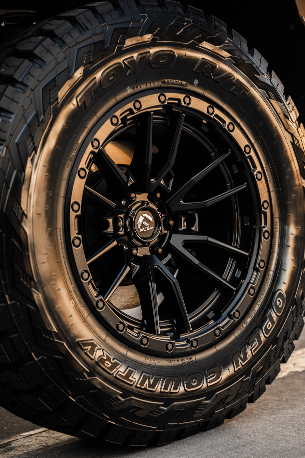Black off-road wheel on a Toyo Open Country tire