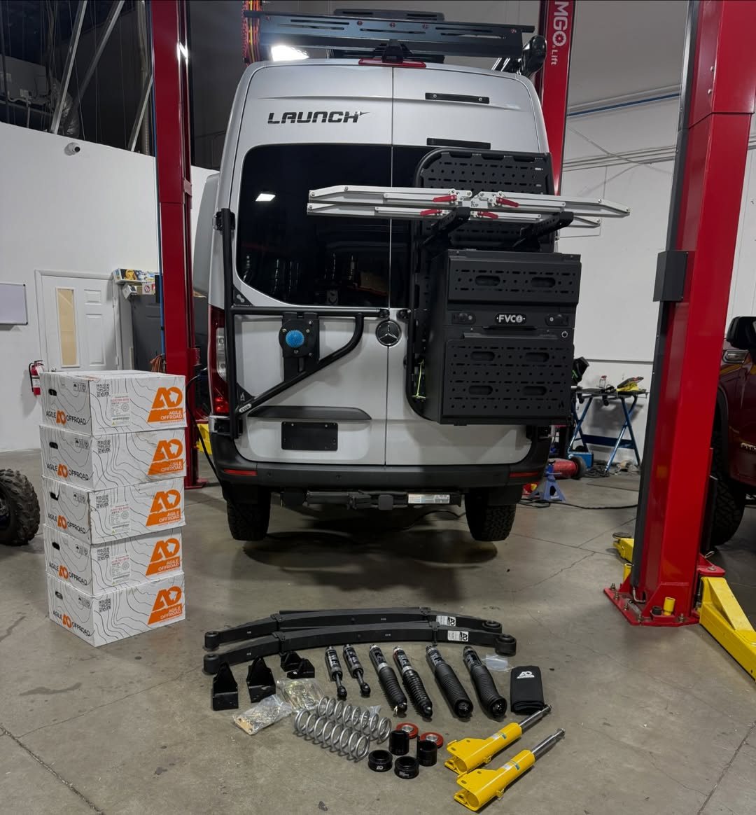 Mercedes Sprinter van on a shop lift with an Agile Off-Road suspension kit laid out on the floor